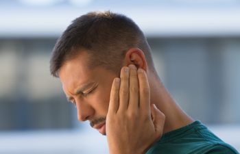Man suffering from ringing in an ear