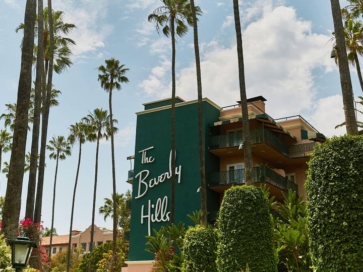The Beverly Hills Hotel sign and pink building among palm trees