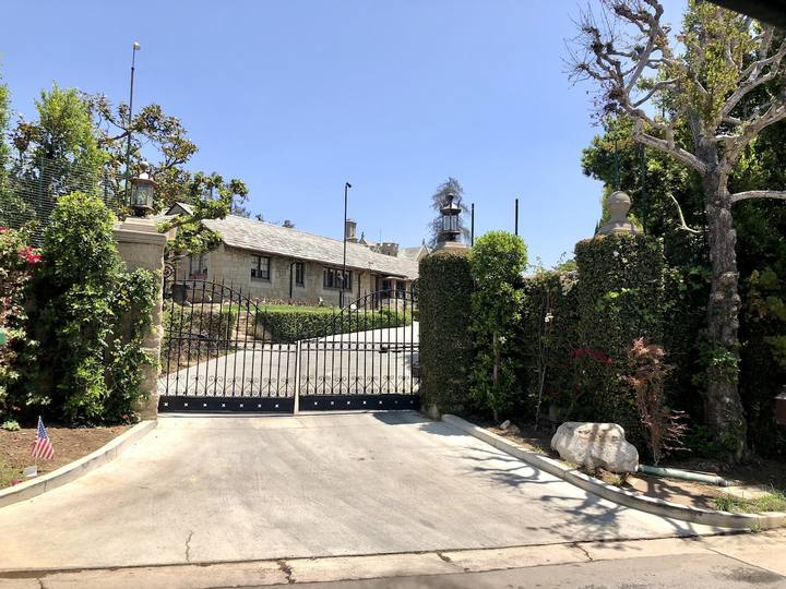 A gated driveway and hedges in Holmby Hills