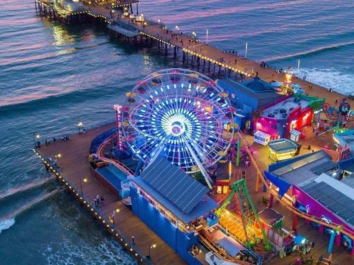Aerial view of the Santa Monica Pier and its lit Ferris wheel at dusk